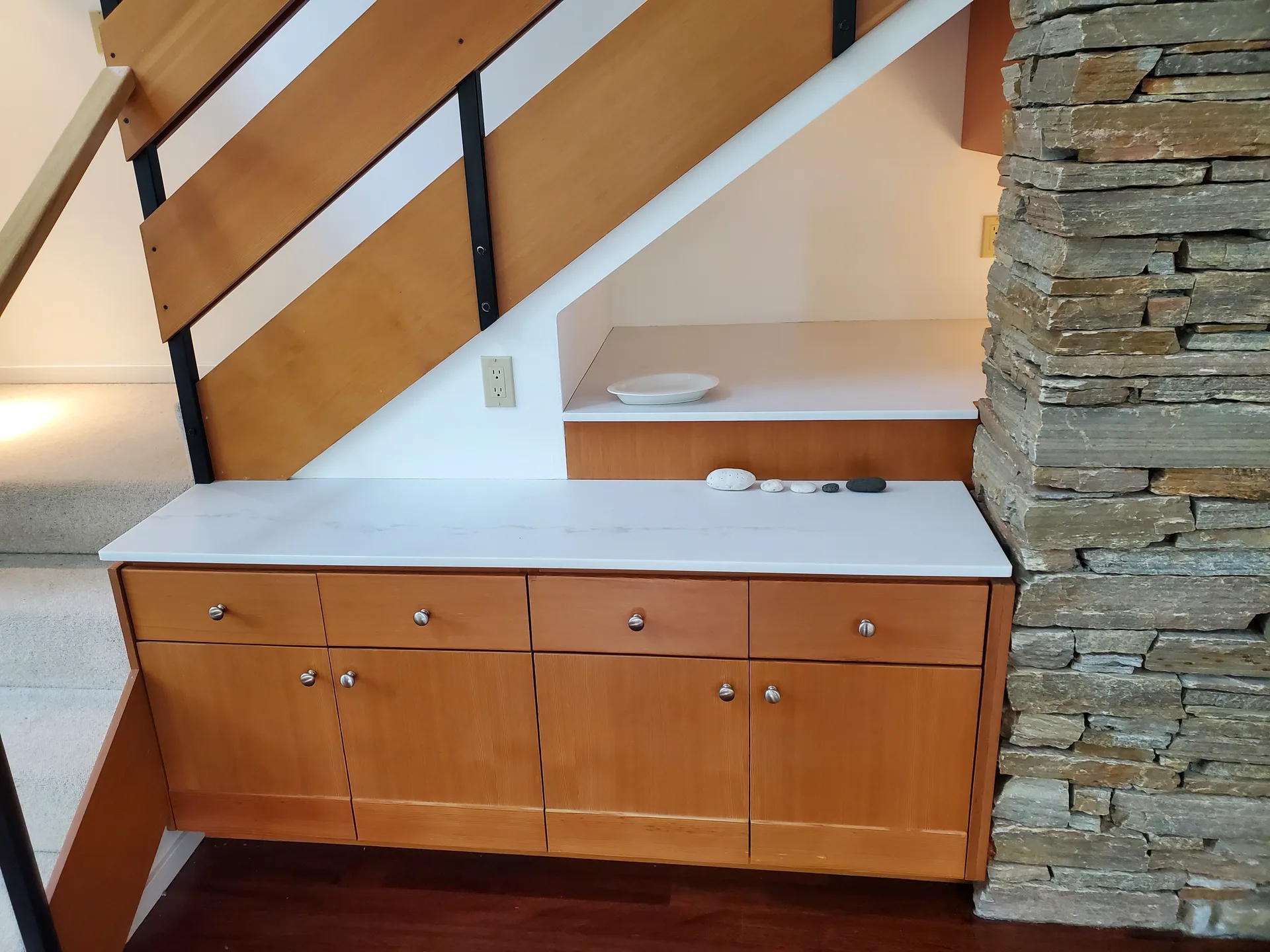 Under-stair wet bar with white marble countertop and stacked stone column