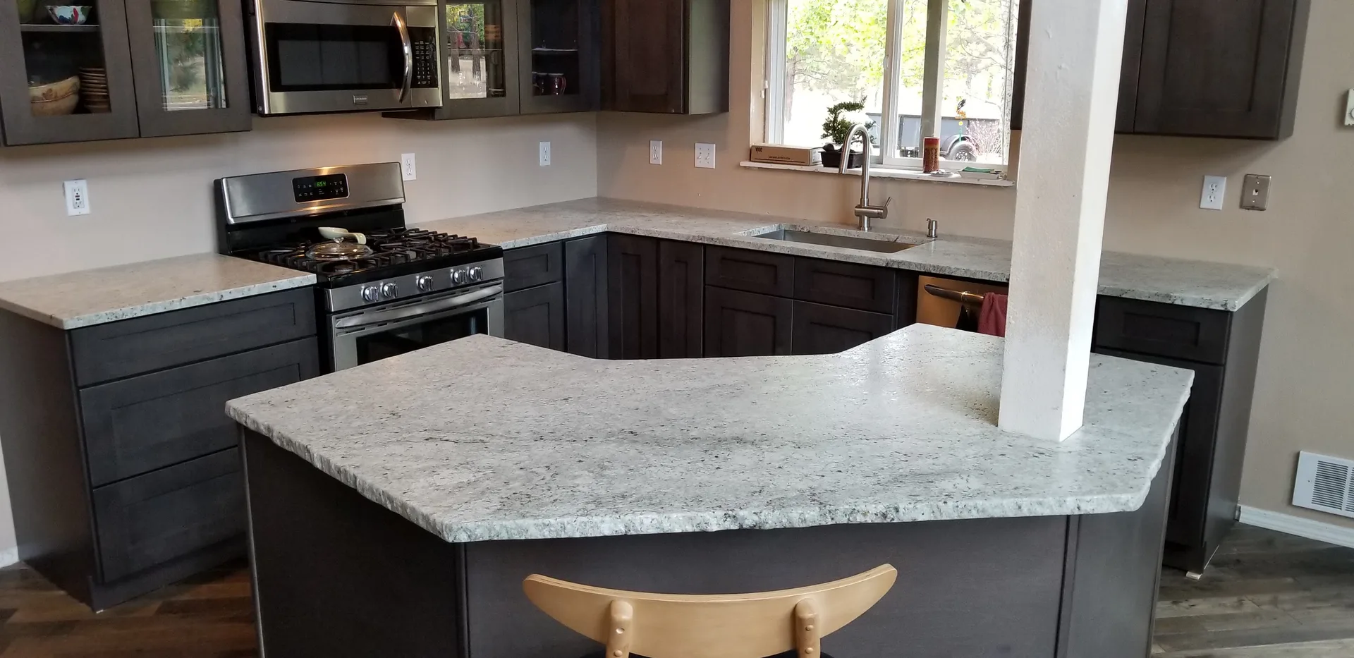 White and gray granite kitchen island with gray cabinets