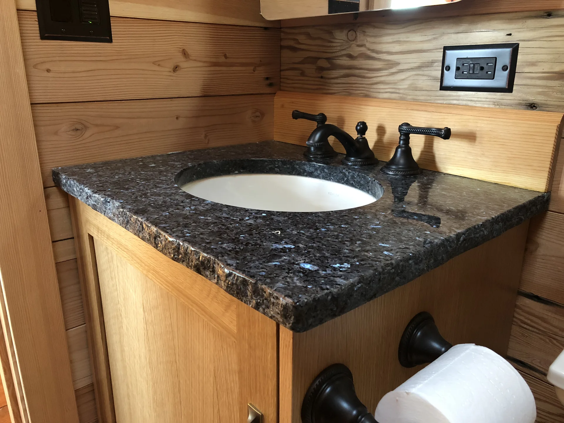 Blue Pearl granite vanity against natural wood plank wall