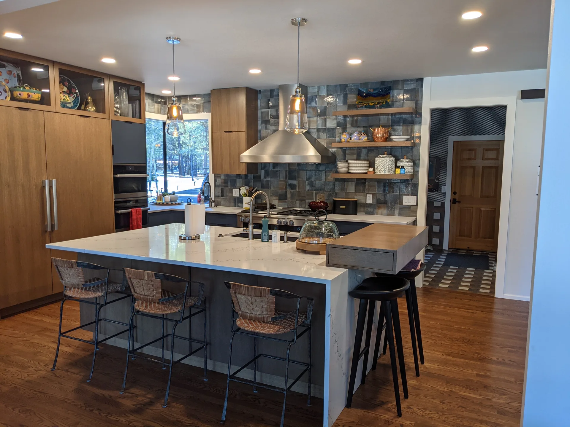 White quartz waterfall island with blue tile backsplash