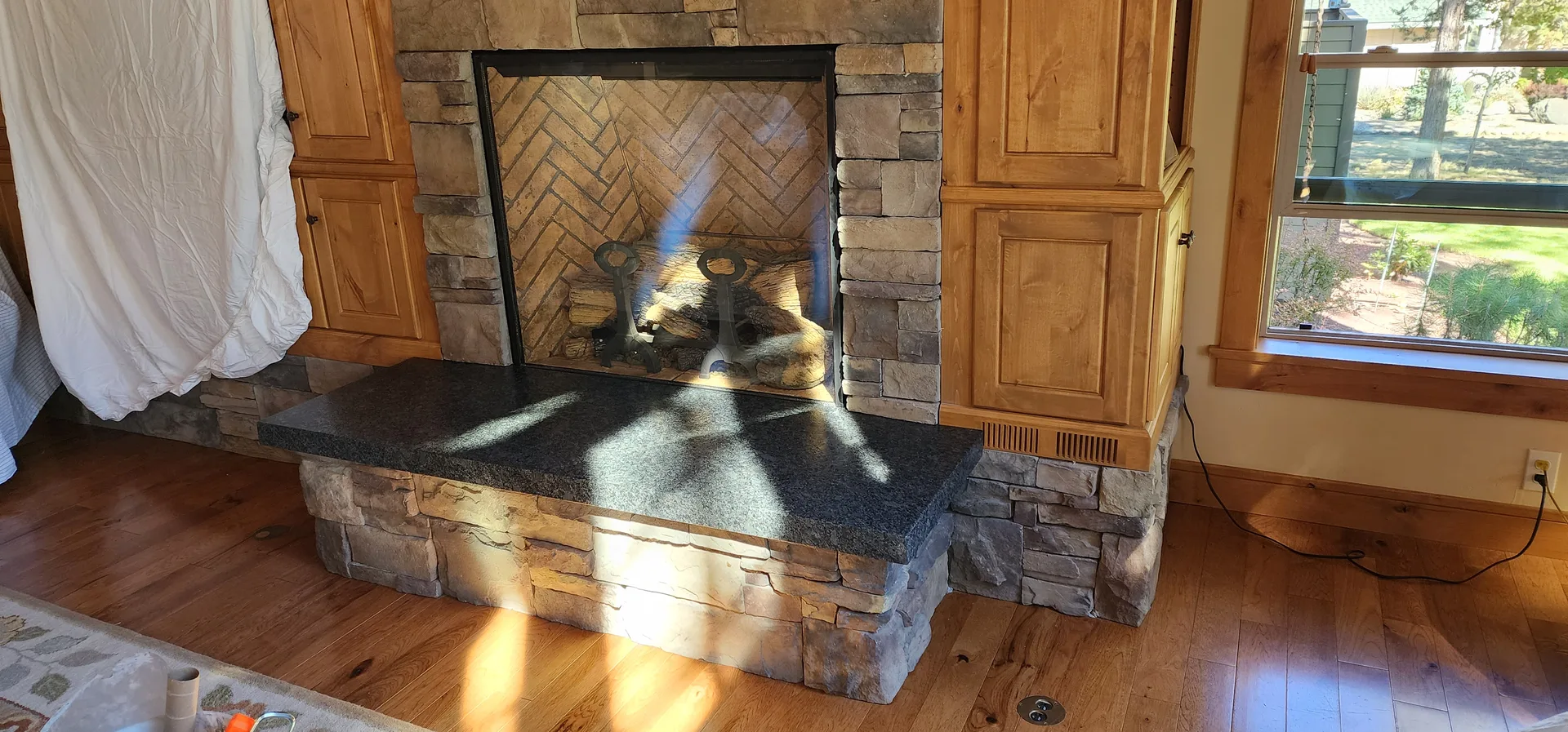 Stacked stone fireplace with black granite hearth