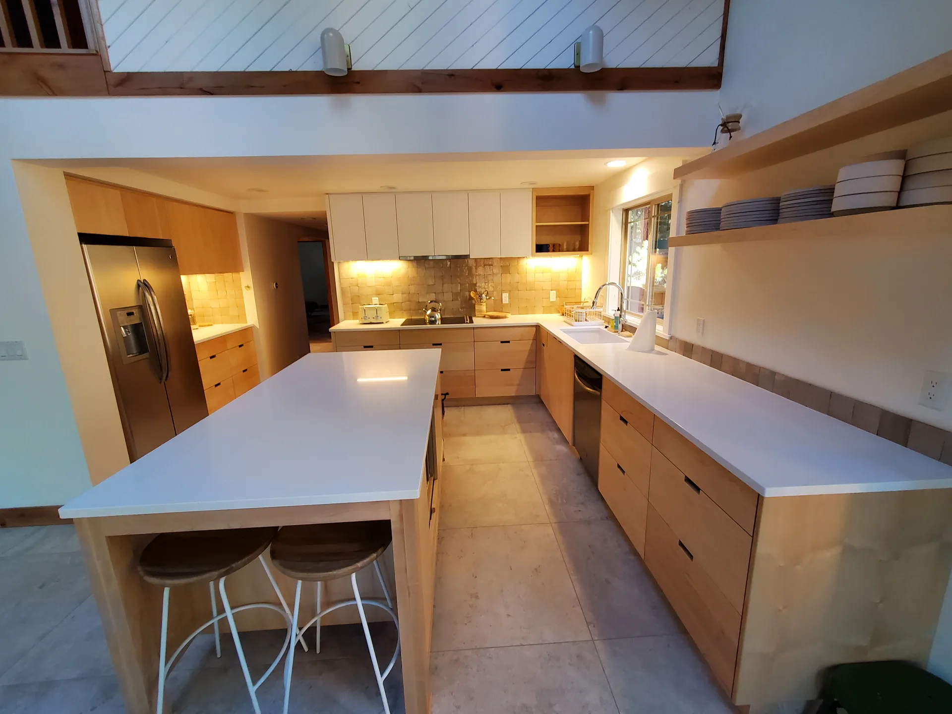 White quartz kitchen island with maple cabinets