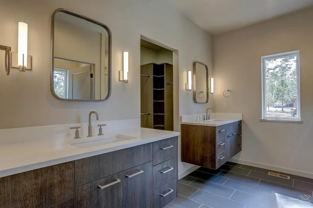 Master bathroom double vanity with white quartz countertop and dark wood cabinets