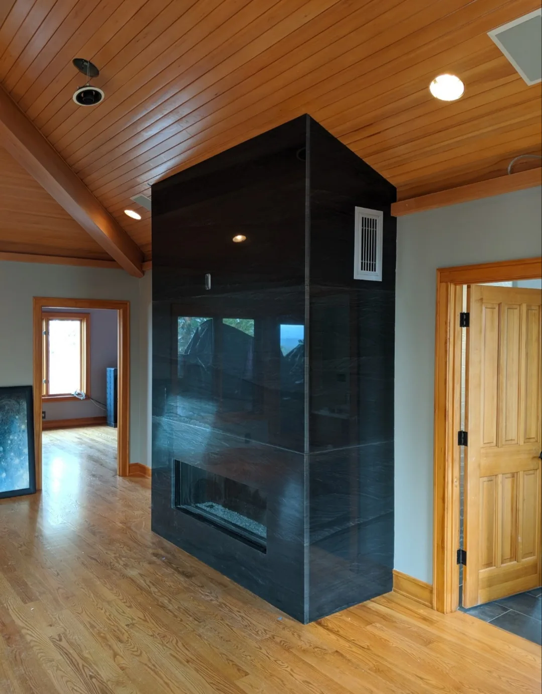 Floor-to-ceiling black stone fireplace surround