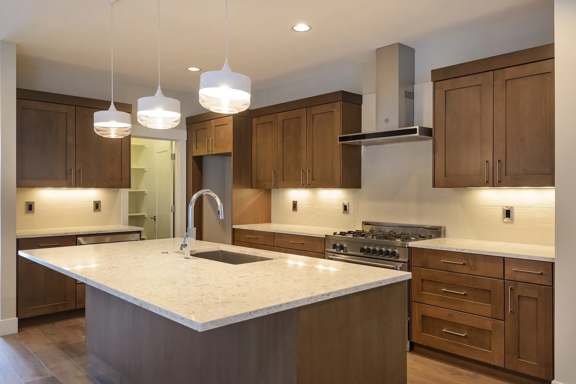 Cream granite kitchen island with natural wood cabinets