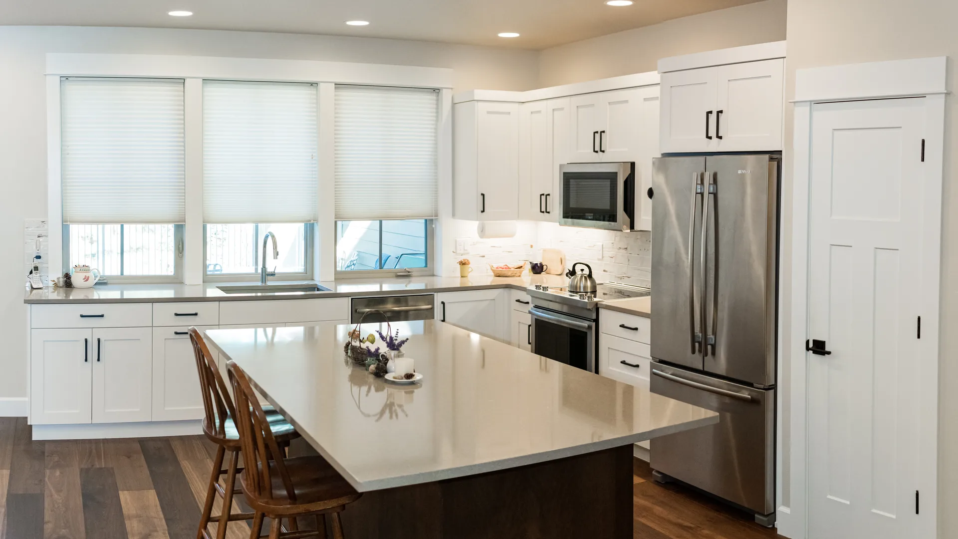 Gray quartz kitchen island with white cabinets
