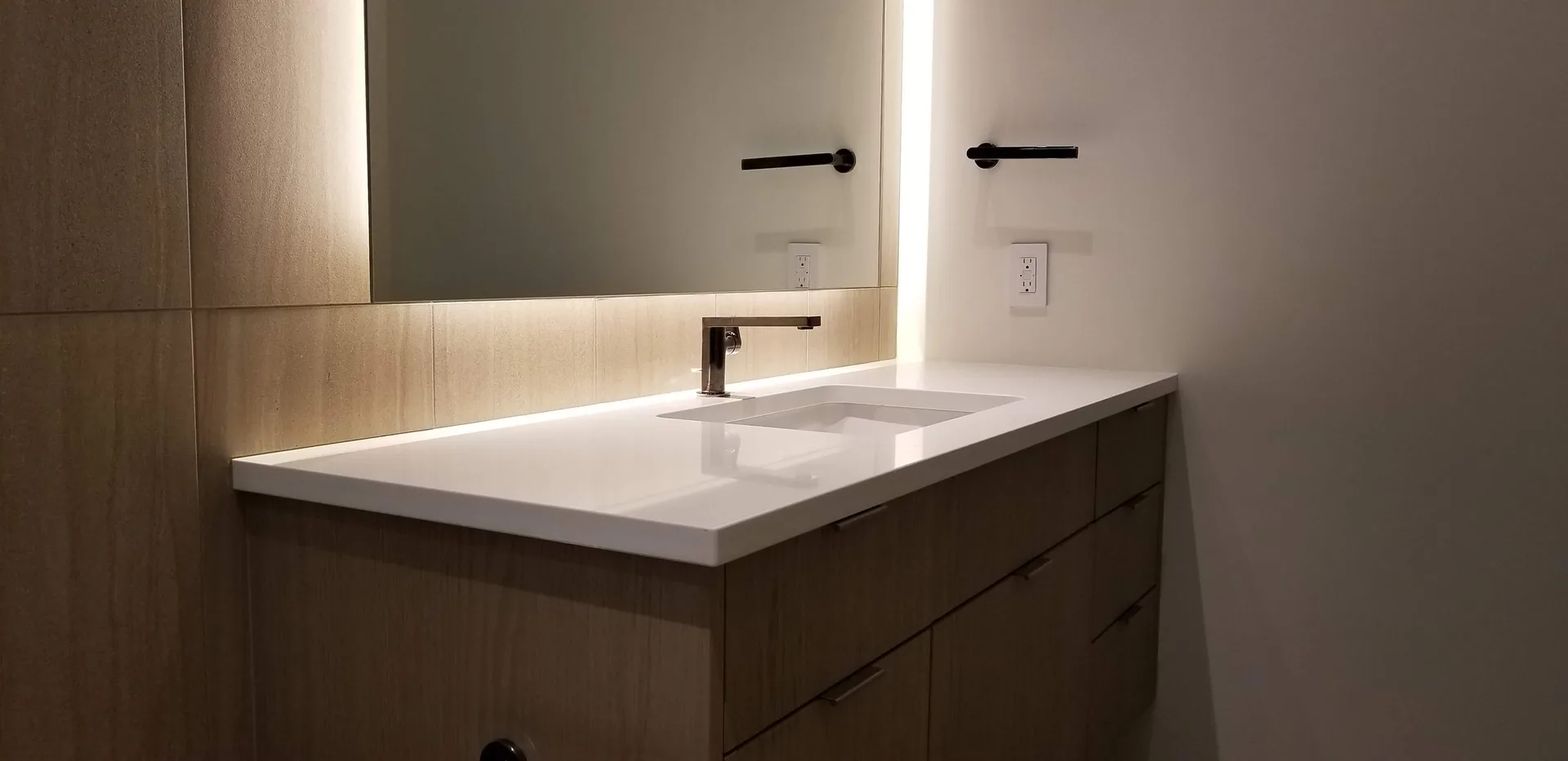 White quartz floating vanity with backlit mirror